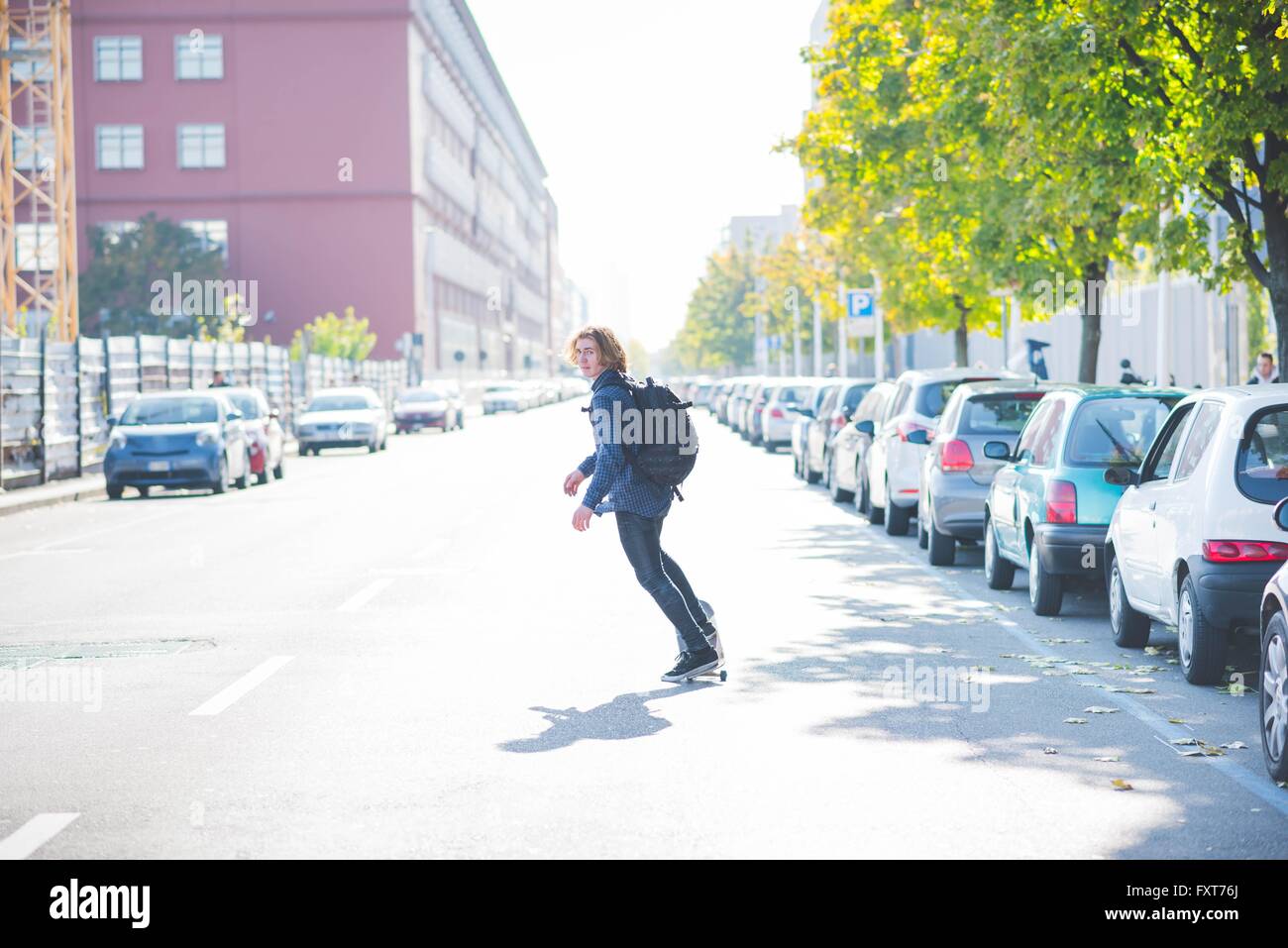 Giovane maschio urbano finta di guidatore di skateboard skateboard su strada Foto Stock