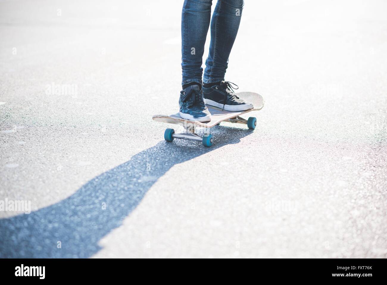 Gambe di maschile urbana finta di guidatore di skateboard skateboard su strada Foto Stock