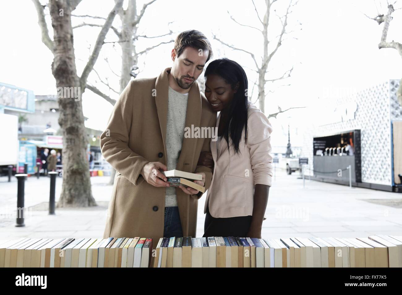 Giovane guardando libri sullo stallo del mercato Foto Stock