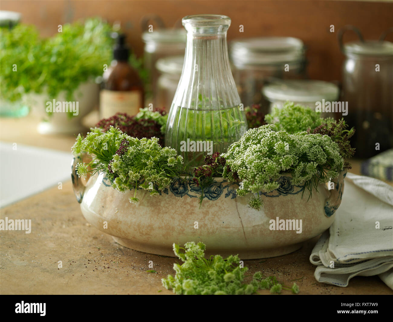 Composizione floreale con fiori selvaggi e ciotola vintage sul banco di cucina Foto Stock