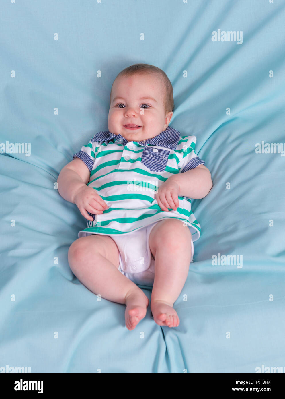 Adorabili happy baby boy su sfondo blu.Focus sulla faccia Foto Stock