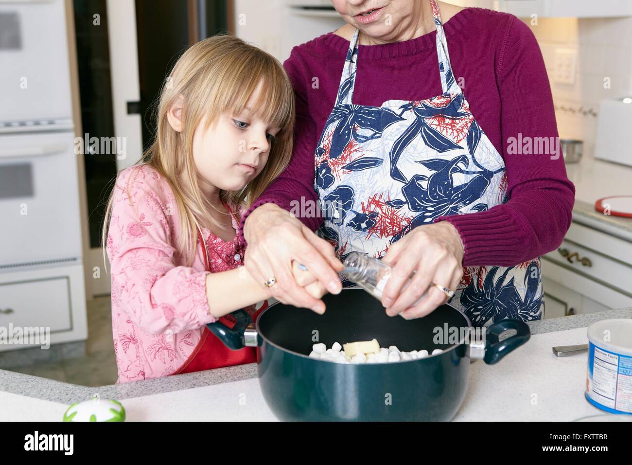 Ragazza e la nonna sale di misurazione per pentola Foto Stock