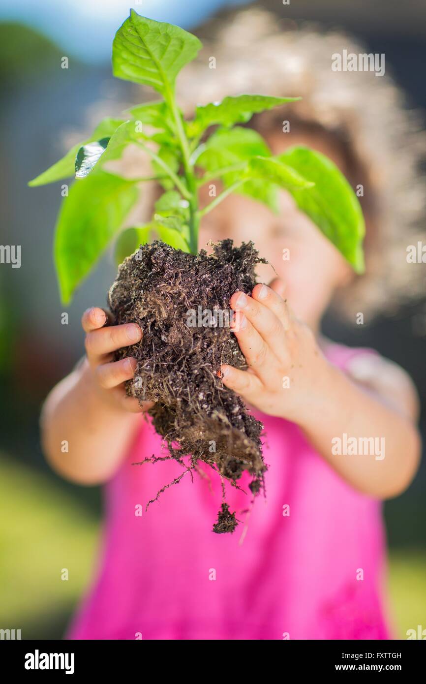 Giovane ragazza in giardino, azienda impianto, lettura per la piantagione di close-up Foto Stock