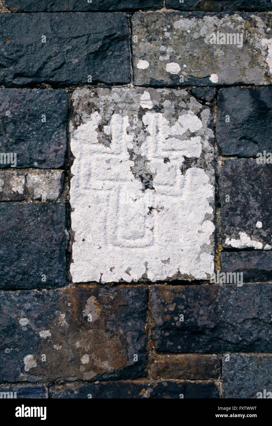 Uno dei cinque primi Cristiani graveslabs costruito nella parete di Gwyndaf St è la Chiesa, Llanwnda, Pembrokeshire, Wales, Regno Unito: doppia incisi a croce latina Foto Stock