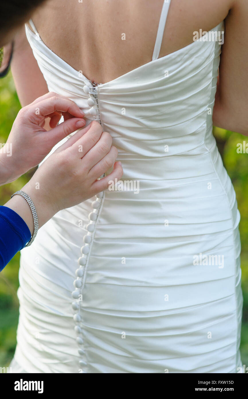 Damigella sta aiutando la sposa per vestire in weddihg giorno Foto Stock