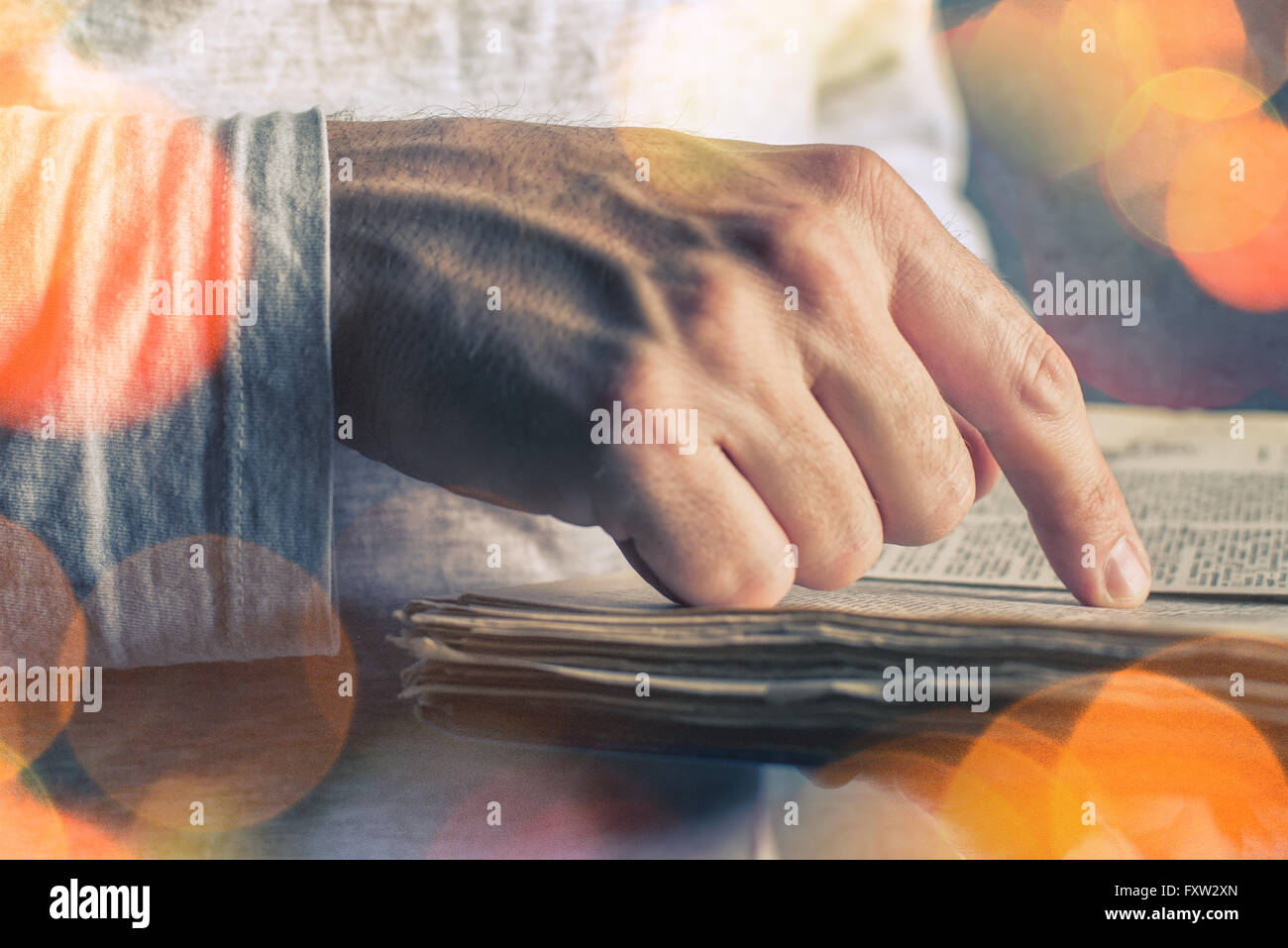 Close up di maschio adulto mani libro vintage, uomo di lettura, bokeh effetto luce Foto Stock