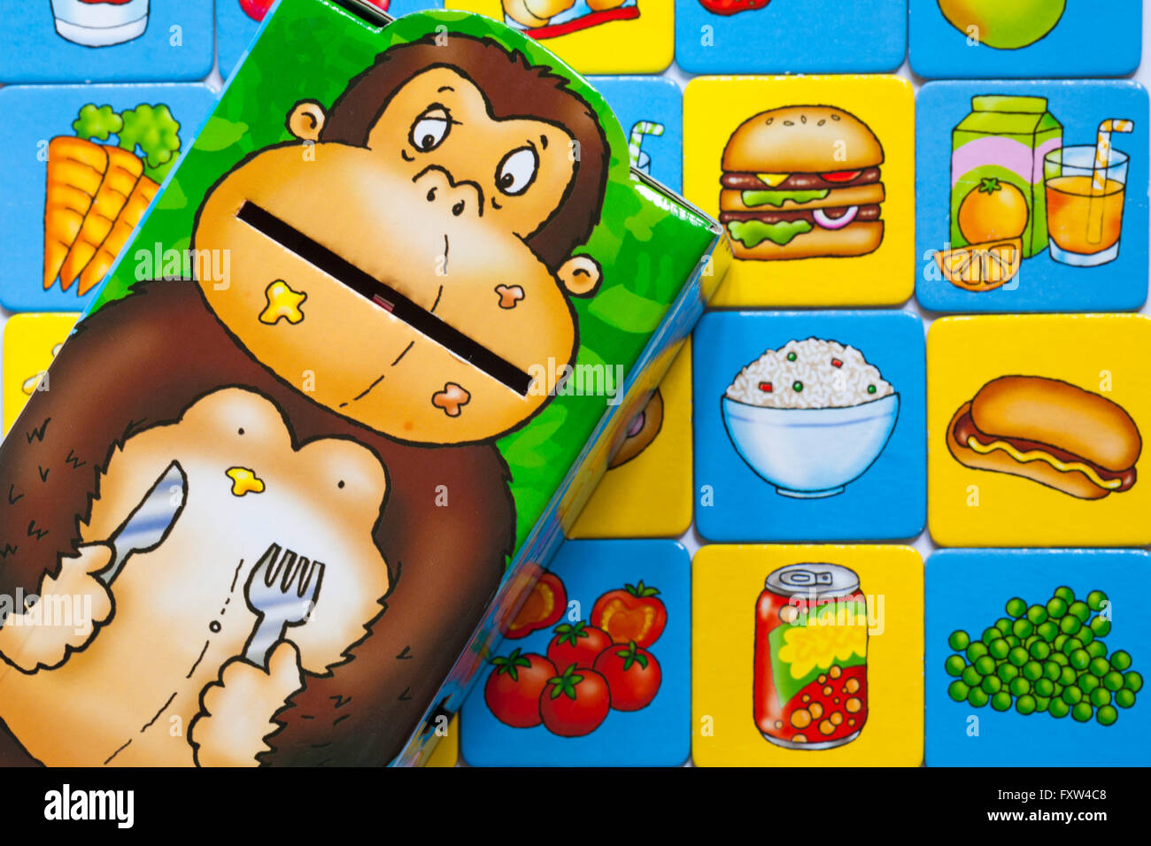 Avidi Gorilla di gioco che mostra le schede alimentari e gorilla - alimentazione il cibo spazzatura per il gorilla mentre si compongono di un pasto sano Foto Stock