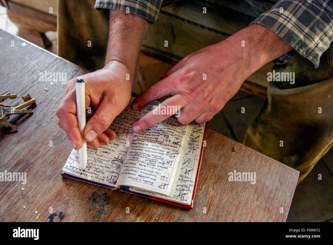 Age memory Senior Man scrive una nota al tuo tascabile quotidiano Senior Person prendendo appunti Foto Stock