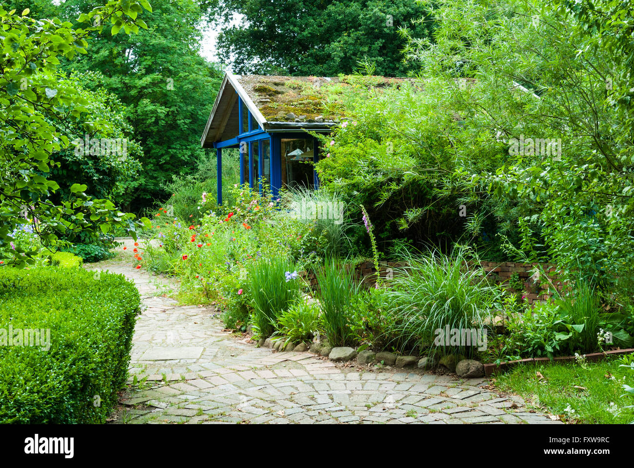 Percorso e cottage in giardino naturale in estate Foto Stock