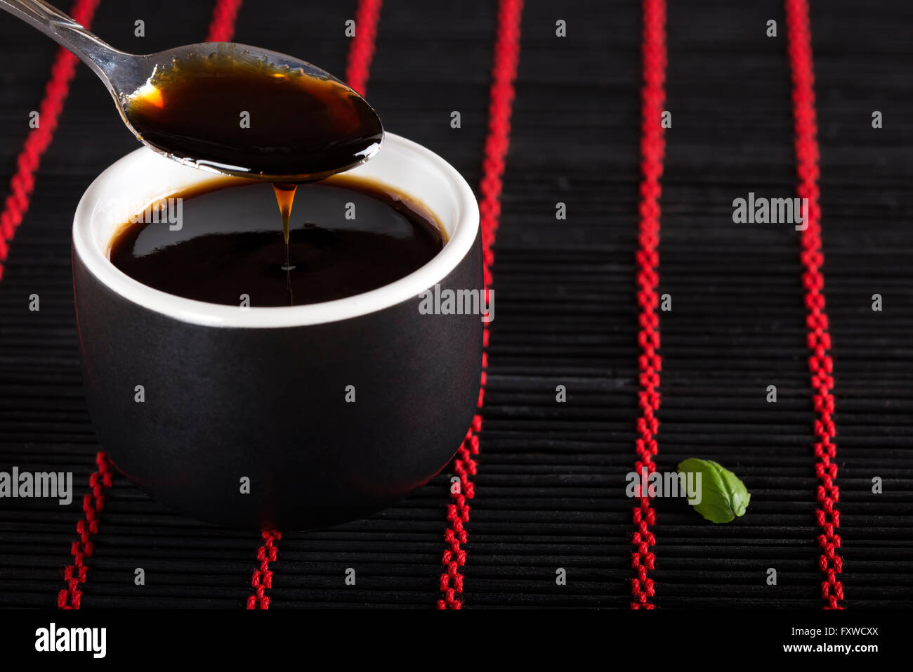 Ciotola di salsa di soia su black bamboo rug Foto Stock