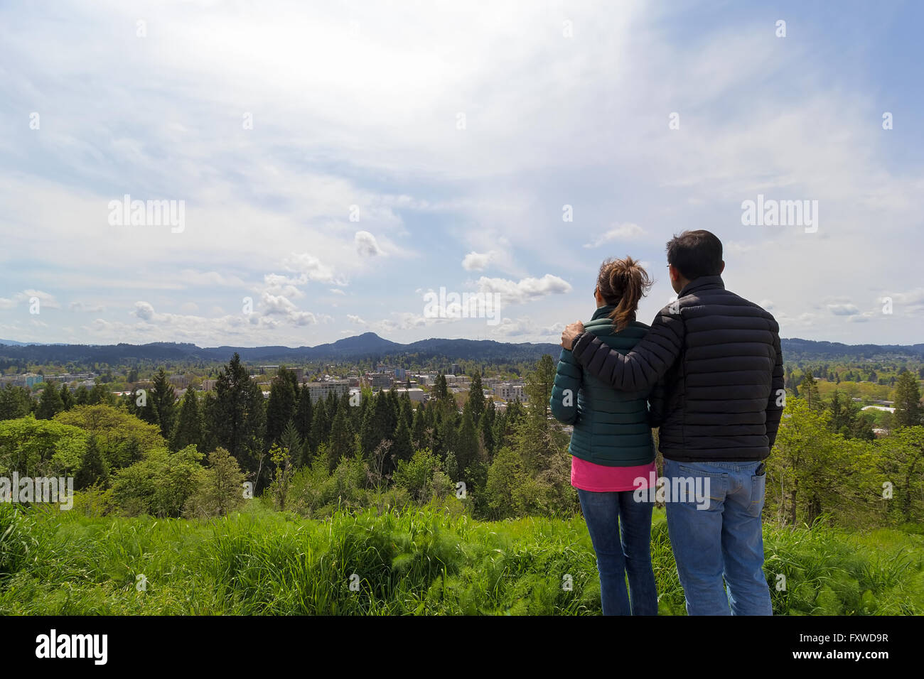 Coppia al top della spellatrice Butte Park gode di vista del centro di Eugene, Oregon su una bella giornata Foto Stock