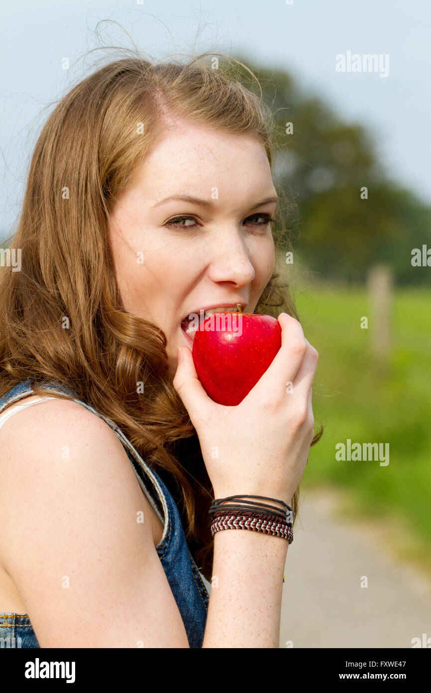 Giovane donna di mangiare un Apple Foto Stock