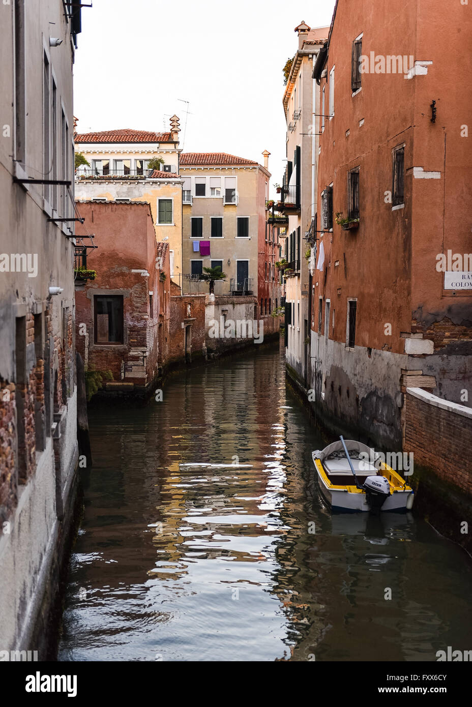 Canale veneziano e barca parcheggiata e vestiti appesi. Foto Stock