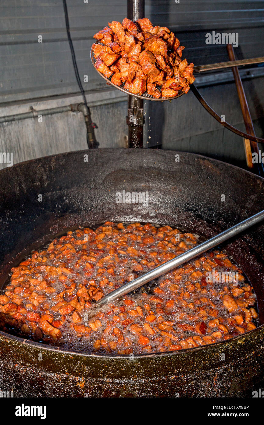 Darby Guillory cuochi di un lotto del suo famoso cracklins...fritte preparate un battuto di lardo di maiale. Lake Charles, LA. Foto Stock