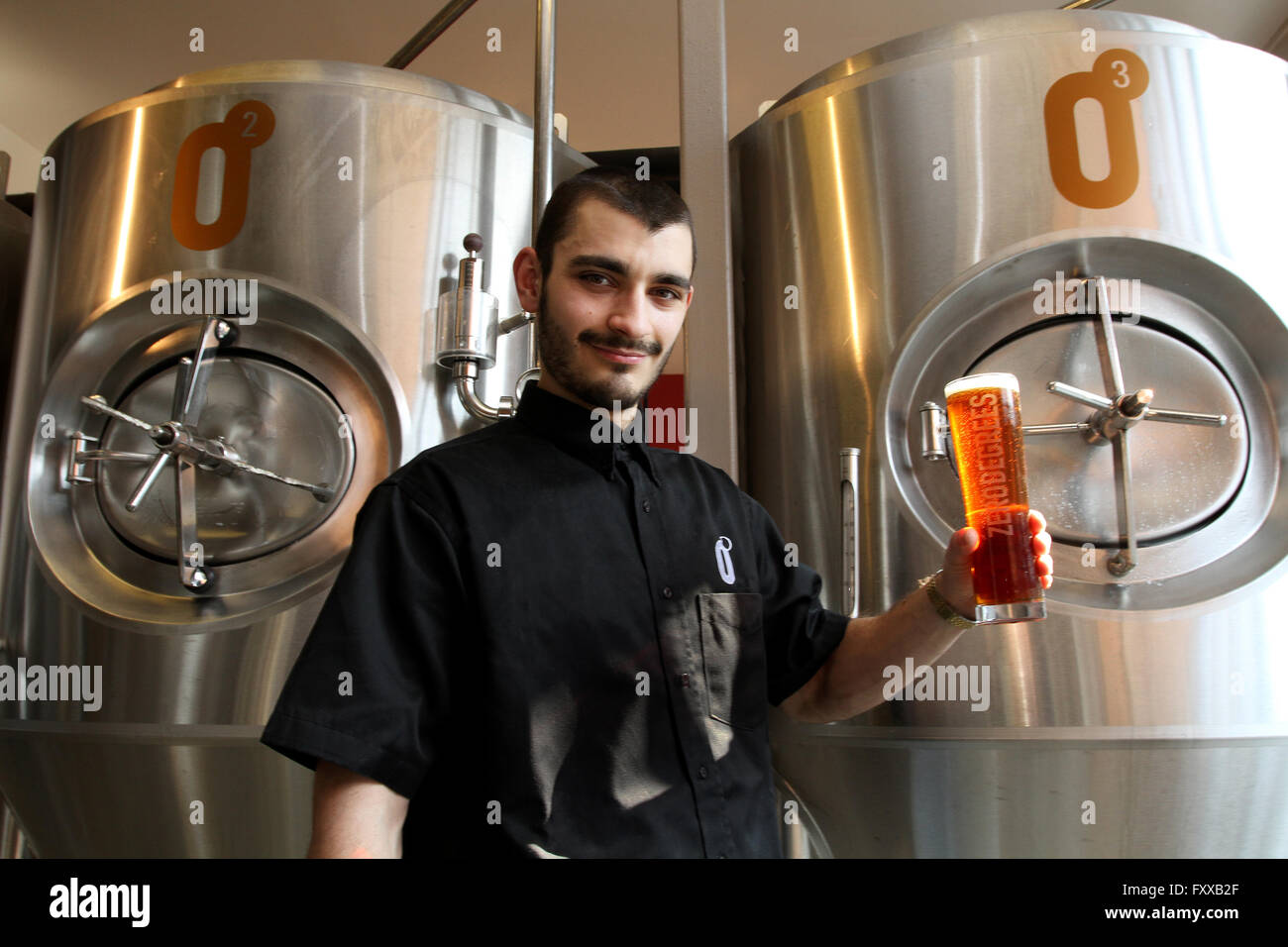 CARDIFF South Wales UK 17.marzo 2016. Cardiff city centre; Brew Pub di zero gradi; Master Brewer Andrei Moisa contiene fino il suo vetro Foto Stock