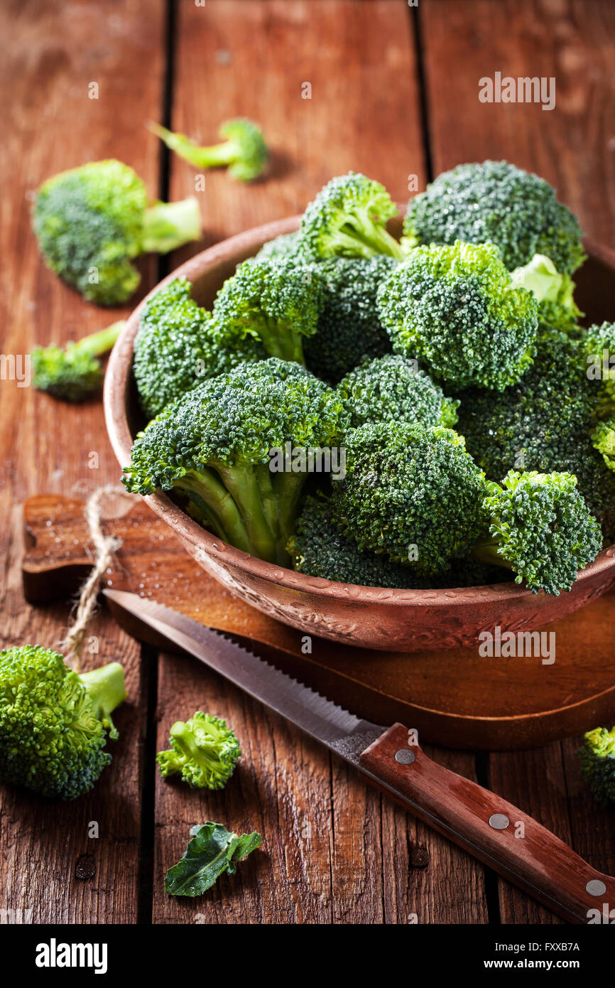 Crudo fresco broccoli verdi nella ciotola di legno rustico sfondo Foto Stock