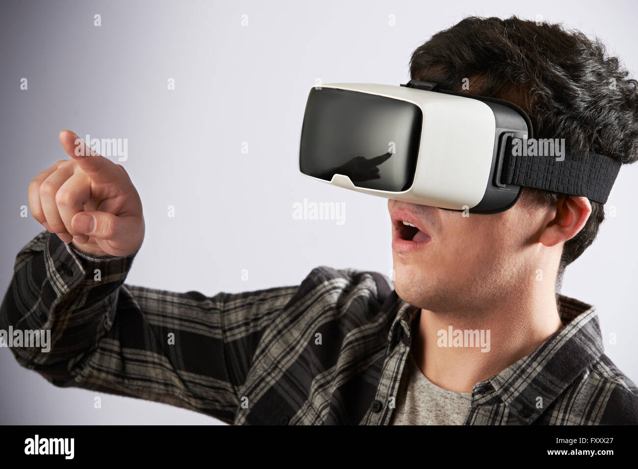 Giovane uomo che indossa la realtà virtuale auricolare Foto Stock