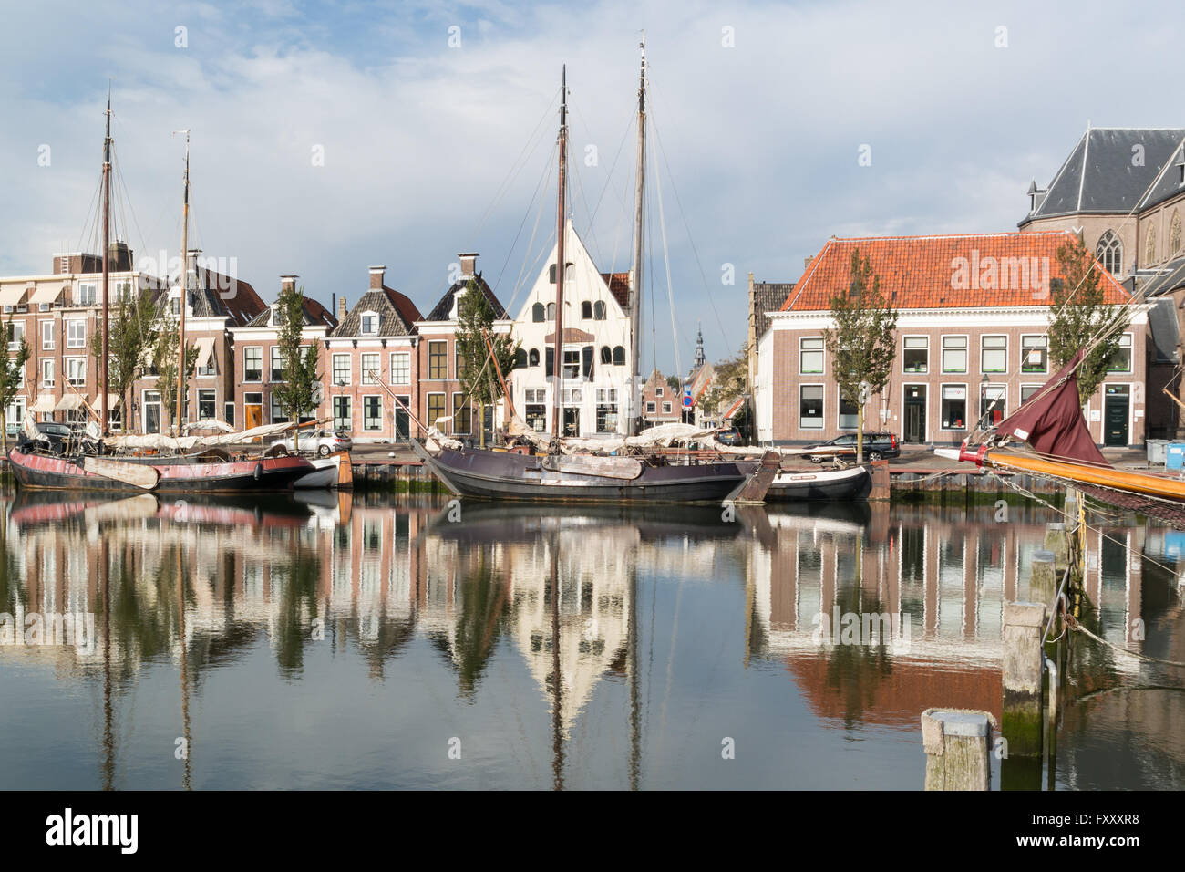 Vecchie case sulla banchina del porto Zuiderhaven canal con barche di Harlingen, Friesland, Paesi Bassi Foto Stock