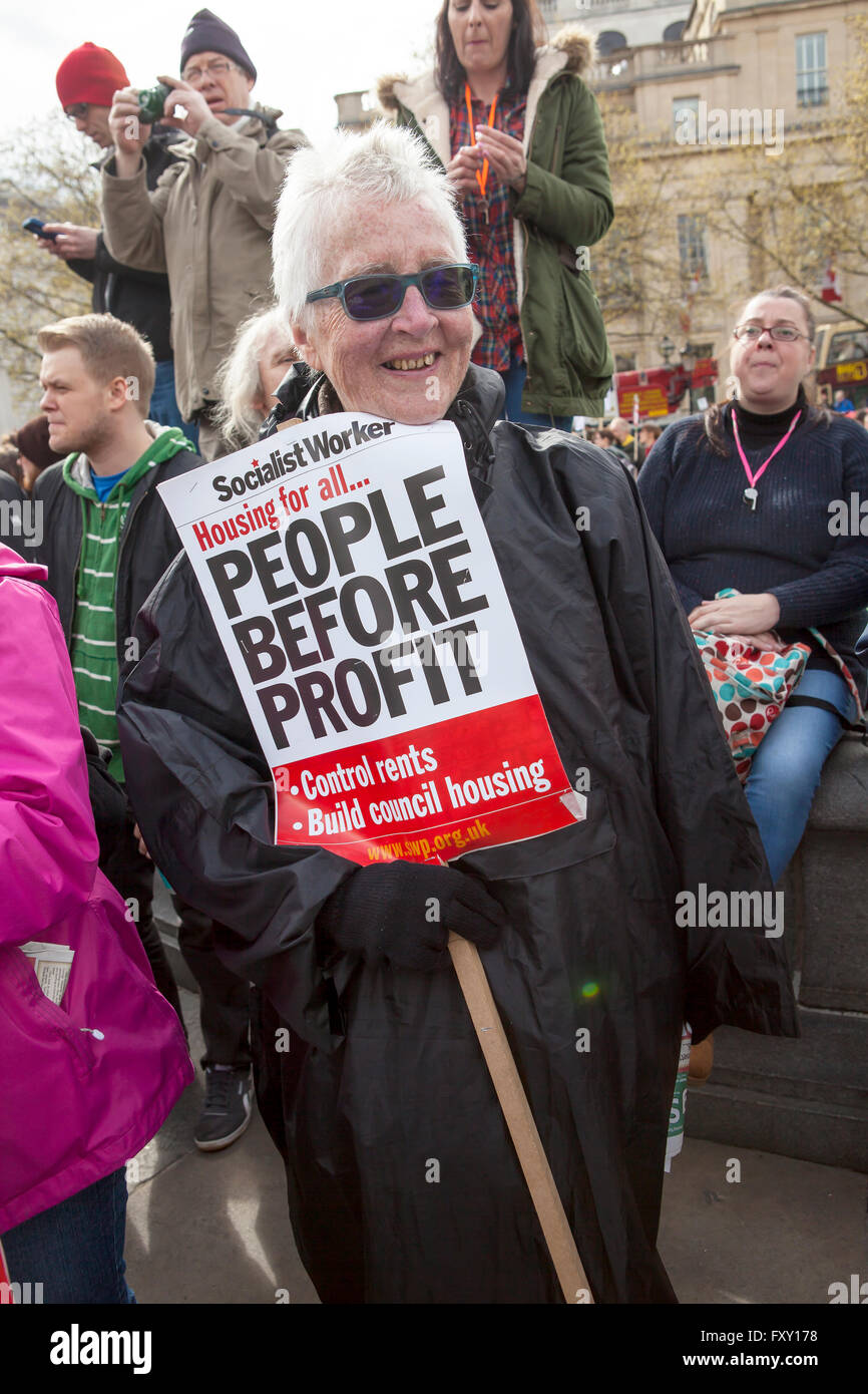 Un senior donna proteste contro il governo austerità che è il taglio di molti programmi di benessere e di colpire il NHS. Foto Stock