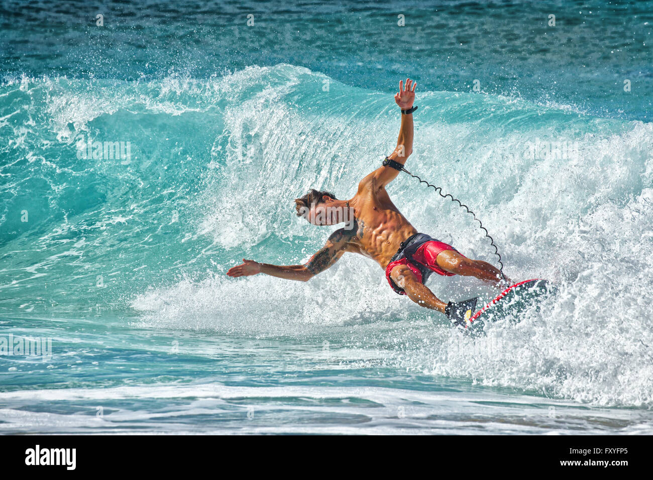 Un bodyboarder perde il suo equilibrio al notoriamente difficile Pipeline surf break in Hawaii. Foto Stock