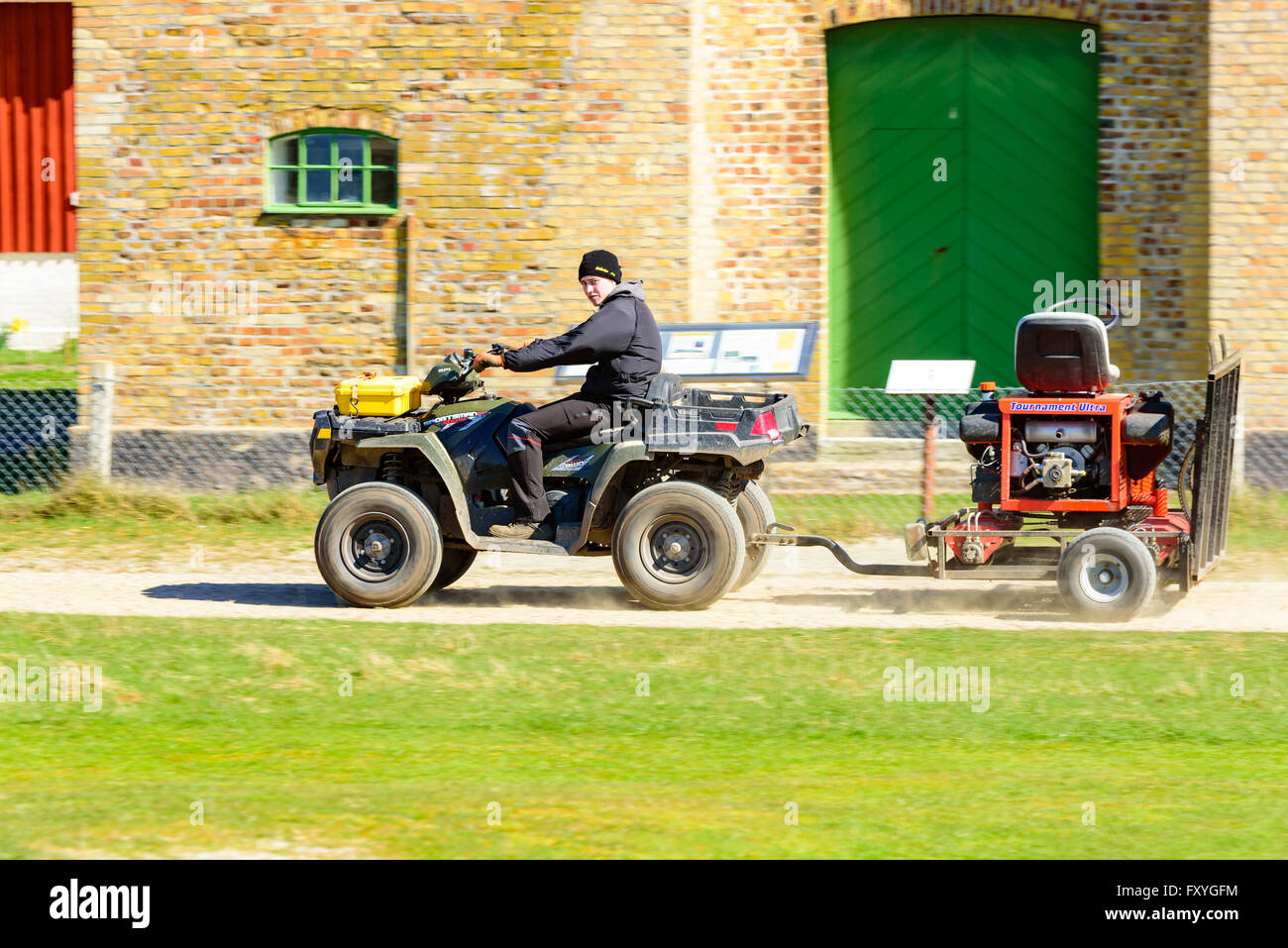 Falsterbo, Svezia - 11 Aprile 2016: Giovani maschi adulti alla guida di un Polaris Sportsman 550 awd con un rimorchio su una strada sterrata. Foto Stock