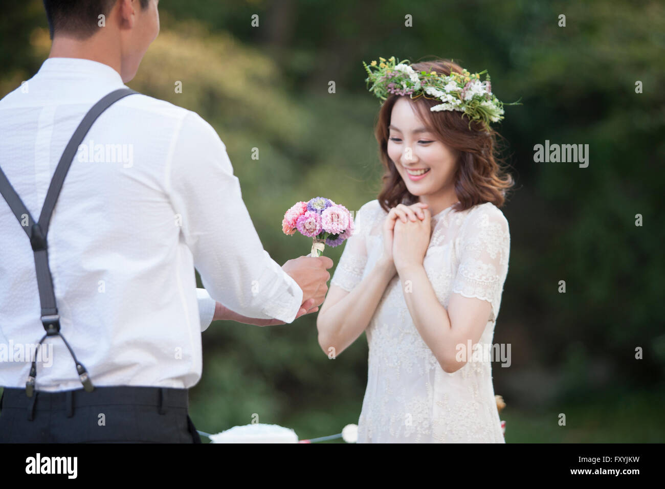 Sposo dando fiori per una sposa Foto Stock