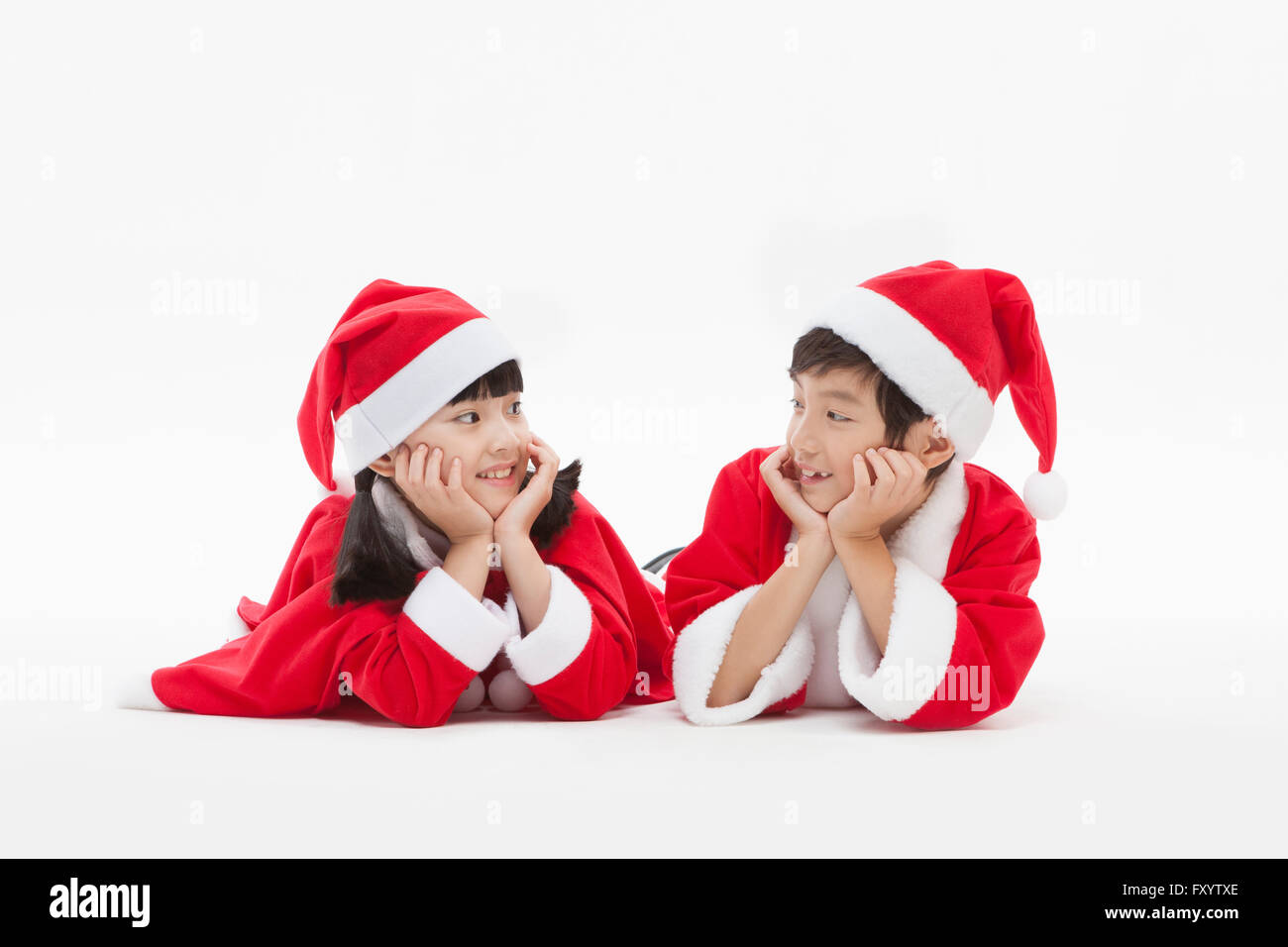 Ritratto di sorridere un ragazzo e una ragazza in santa vestiti di immissione i menti più thier nelle loro mani faccia a faccia Foto Stock