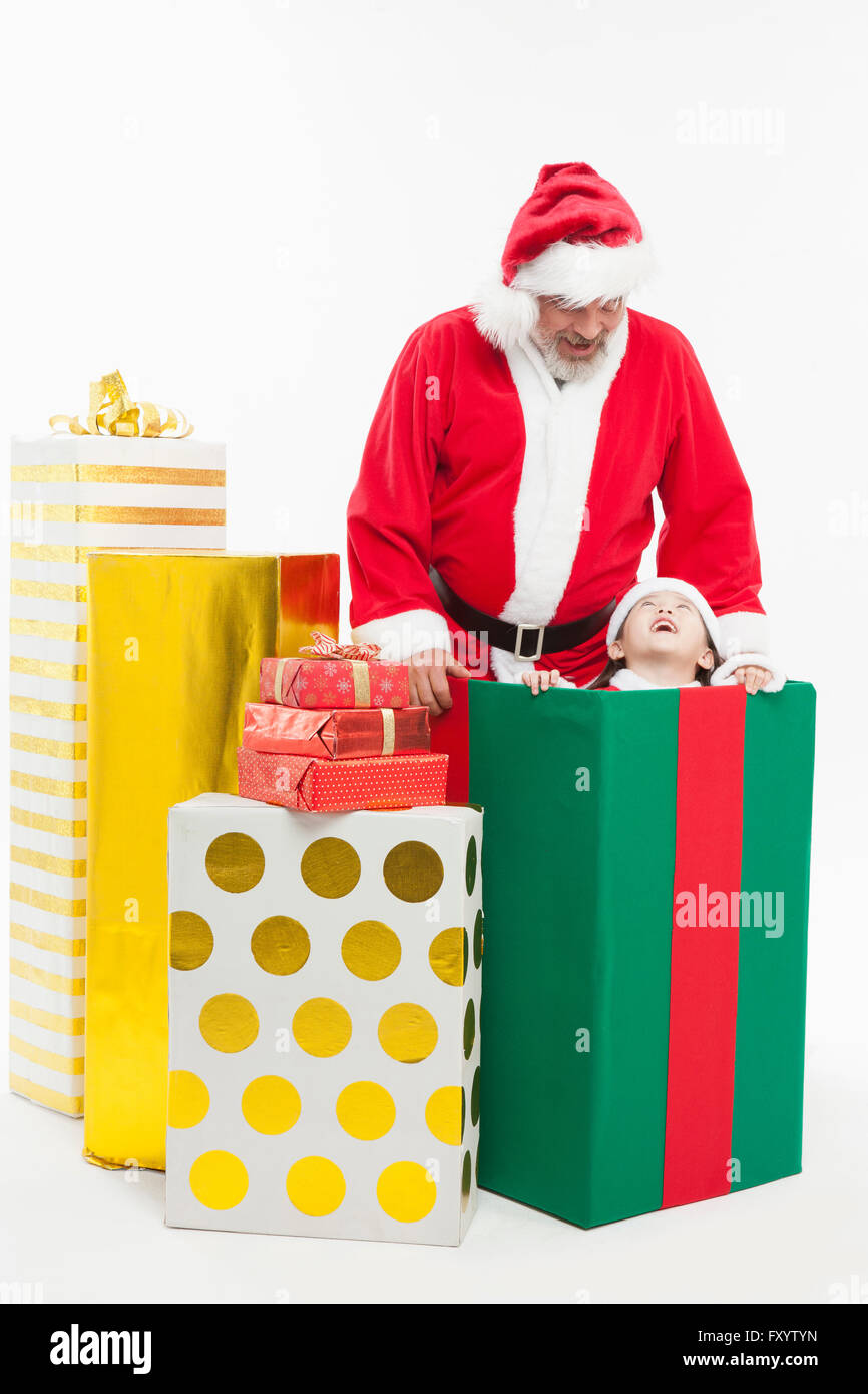 Sorridente Babbo Natale e la bambina faccia a faccia con le caselle presenti Foto Stock