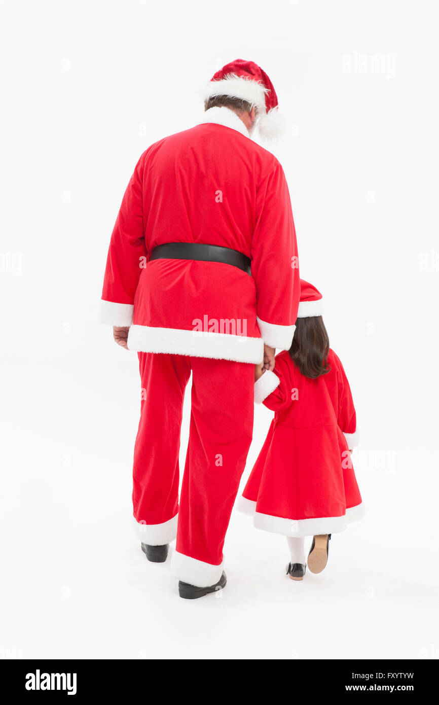 Spalle di Santa Claus e grill camminando mano nella mano Foto Stock