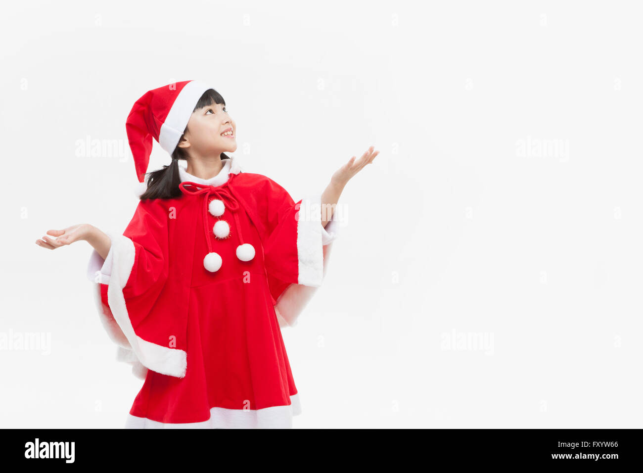Ritratto di ragazza sorridente in costumi di Natale dei braccetti di trattenimento cercando Foto Stock