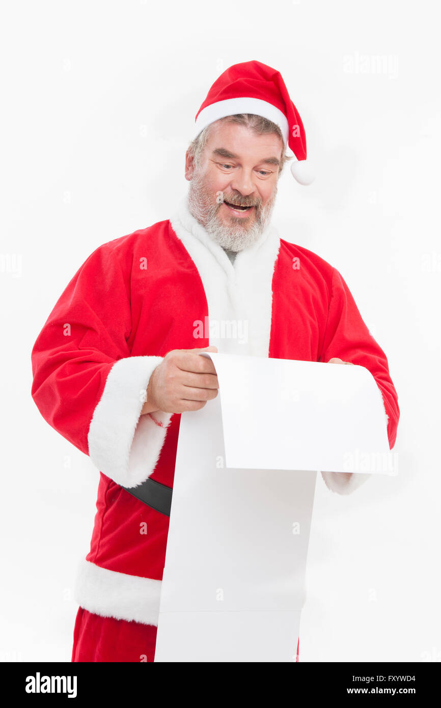 Sorridente Santa holding e guardando verso il basso al lungo elenco Foto Stock