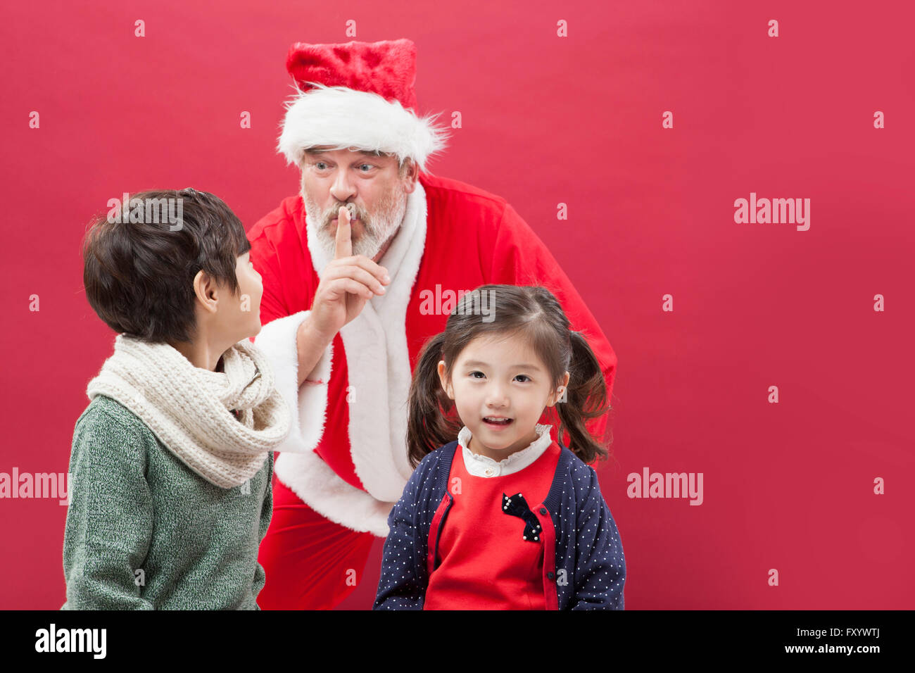 Ritratto di sorridente ragazza che fissa sul lato anteriore, ragazzo sorridente e santa mettere il dito sulle labbra faccia a faccia Foto Stock