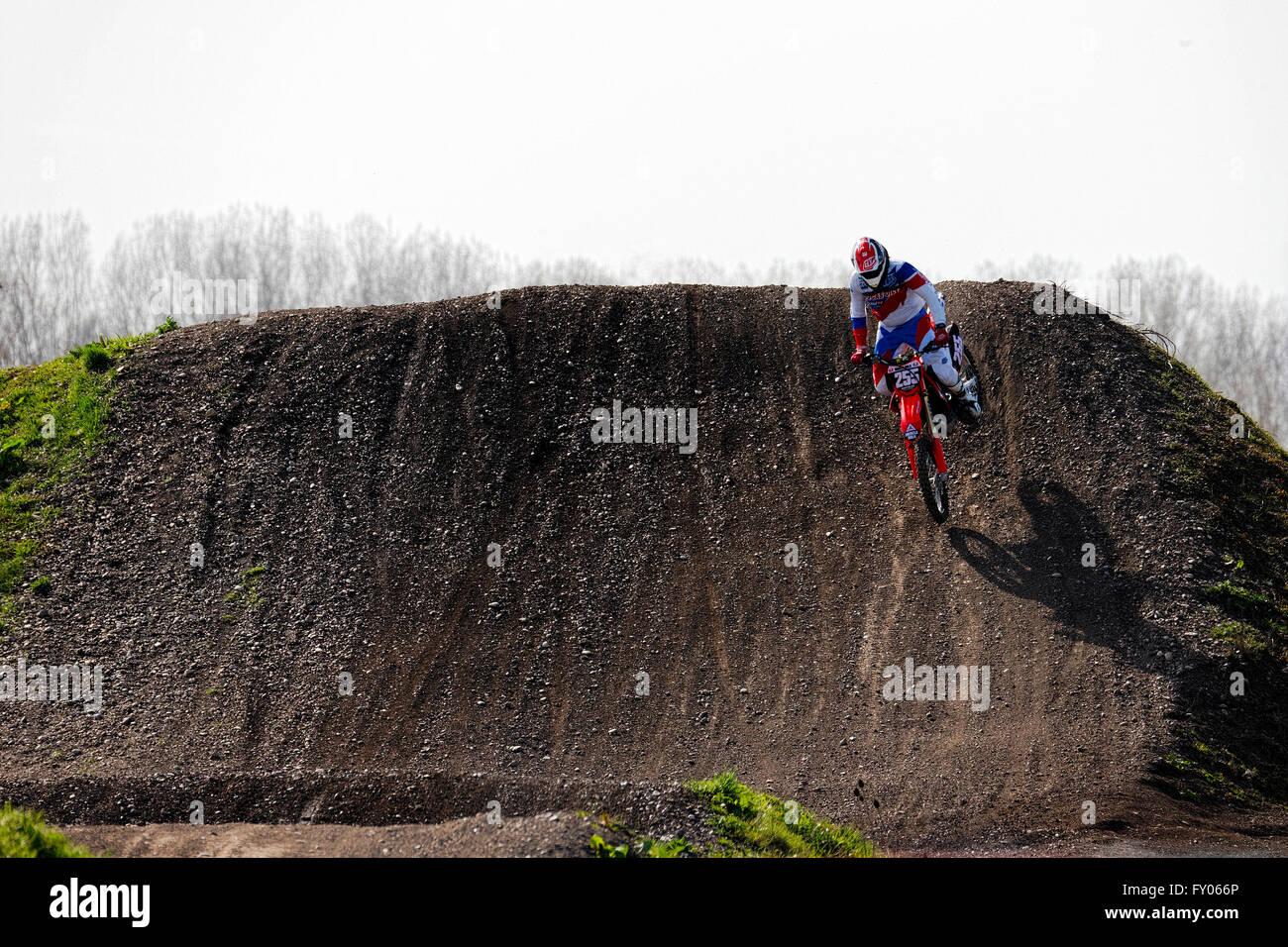 Il motocross rider racing la discesa da un pendio, München Flughafen, Alta Baviera, Germania, Europa. Foto Stock