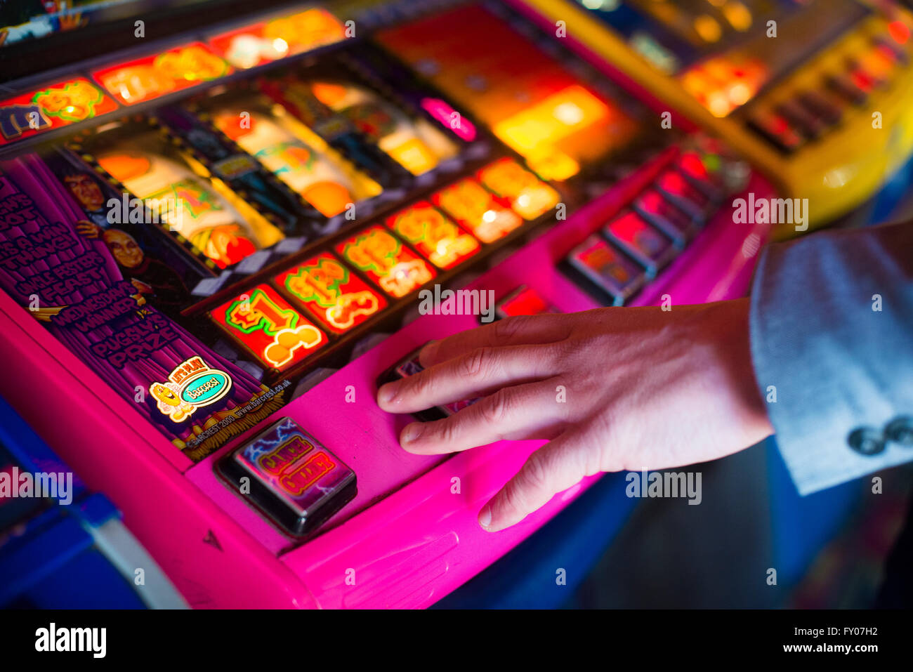 Una mano d'uomo su una macchina di frutta il gioco d'azzardo Foto Stock