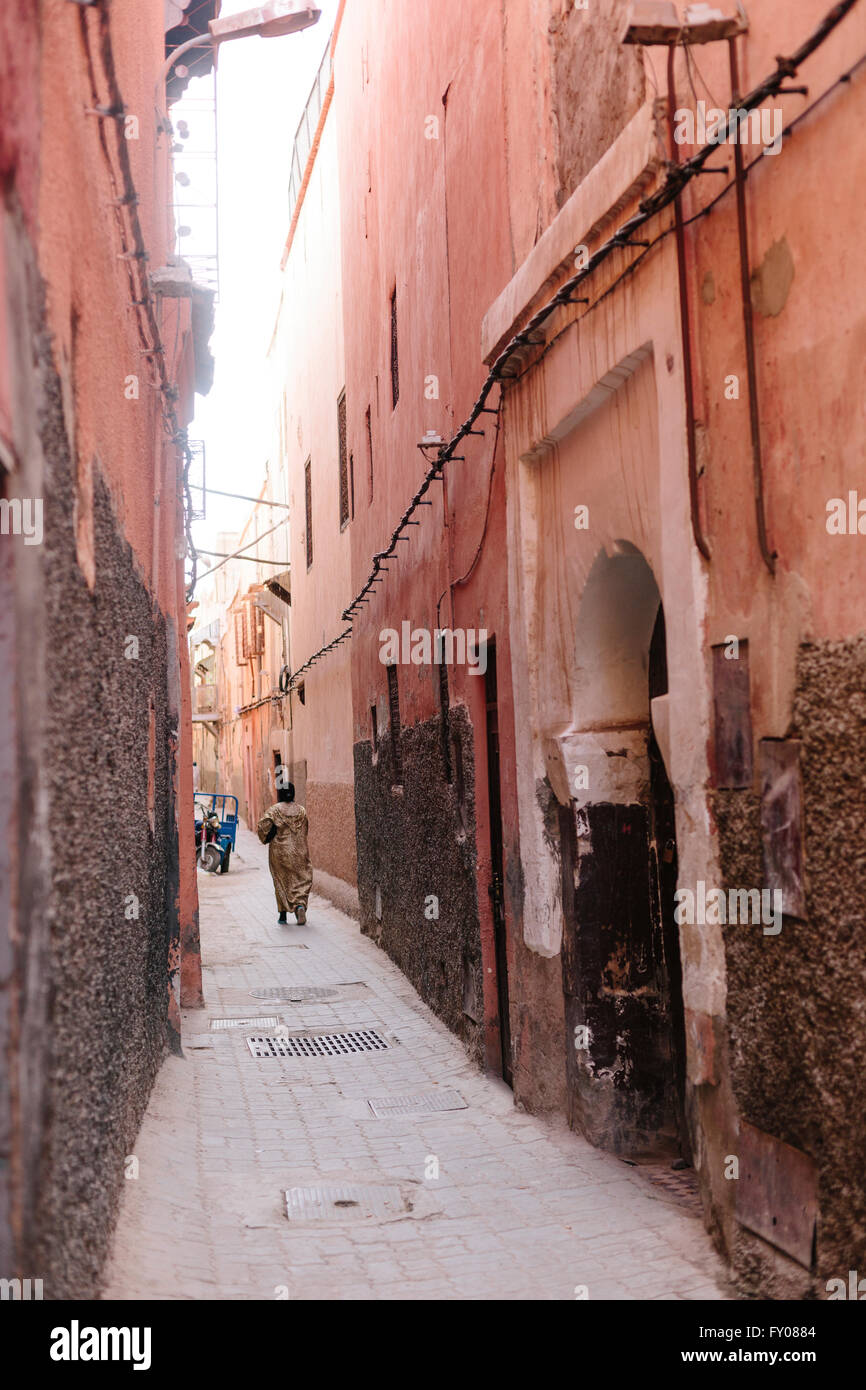 Una donna locale cammina per un tipico vicolo modo nel Mellah (quartiere ebraico) di Marrakech in Marocco Foto Stock
