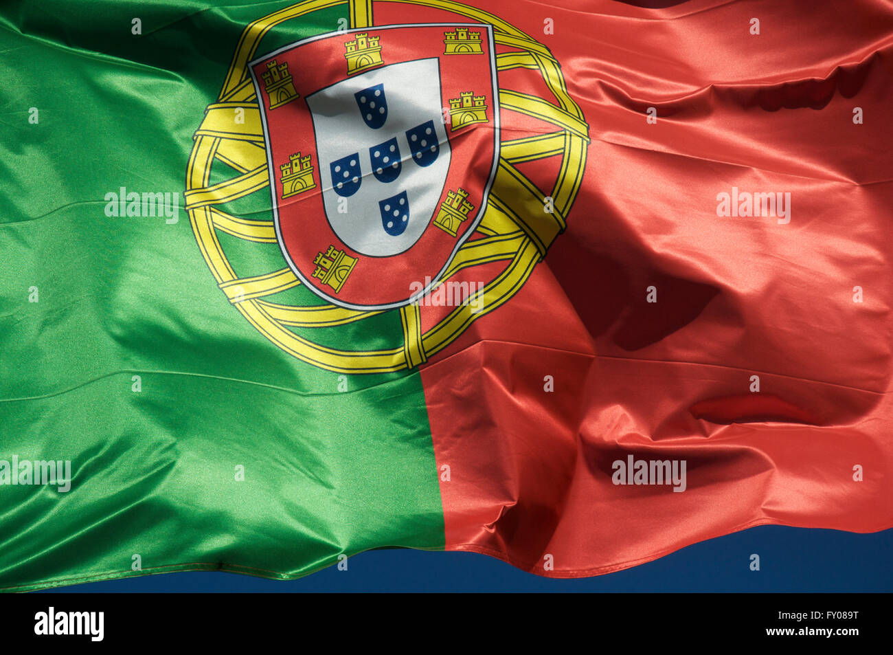 Una chiusura del rosso e verde bandiera nazionale della Repubblica portoghese, "Bandeira de Portugal". In volo la brezza. Foto Stock