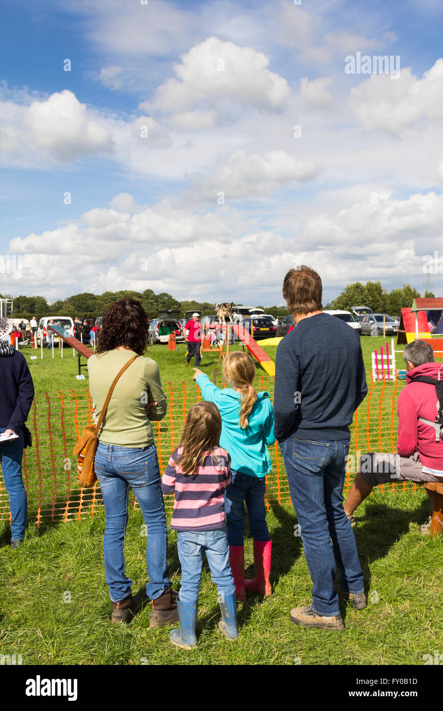 Una giovane famiglia guardando il cane agilità dimostrazione presso il Lancashire gioco e Country Festival 2015 in Scorton. Foto Stock