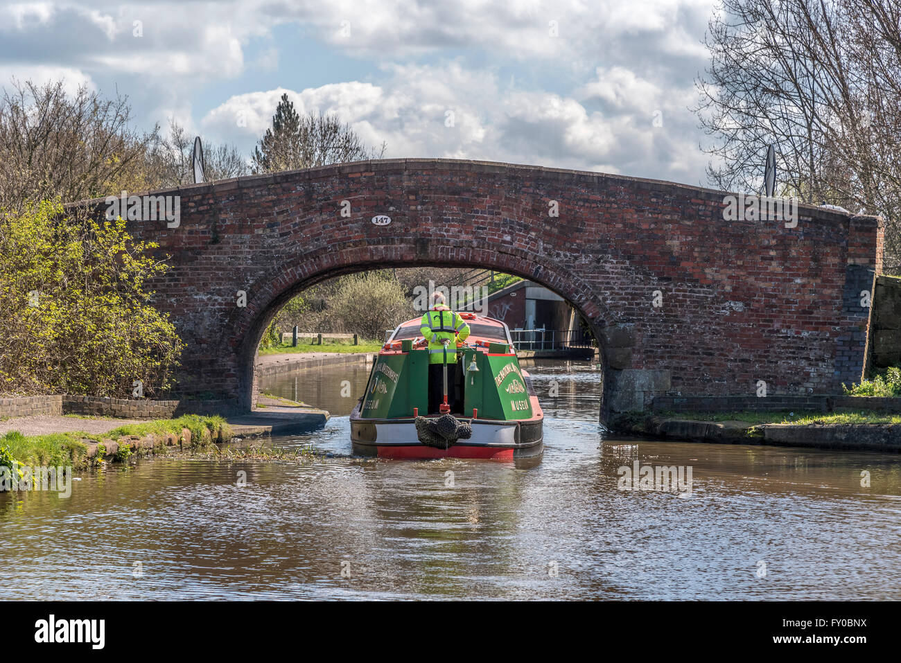 Canal narrowboat passa sotto un vecchio ponte di mattoni sul National Waterways Museum di Ellesmere Port Cheshire, Inghilterra, Foto Stock