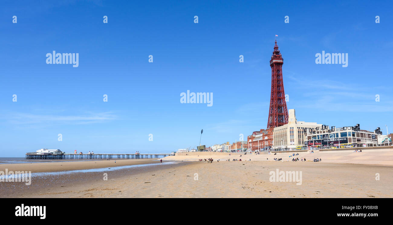 Sotto un luminoso cielo blu, la vista dalla spiaggia sabbiosa di North Pier e la mitica Torre di Blackpool in Blackpool Lancashire Foto Stock