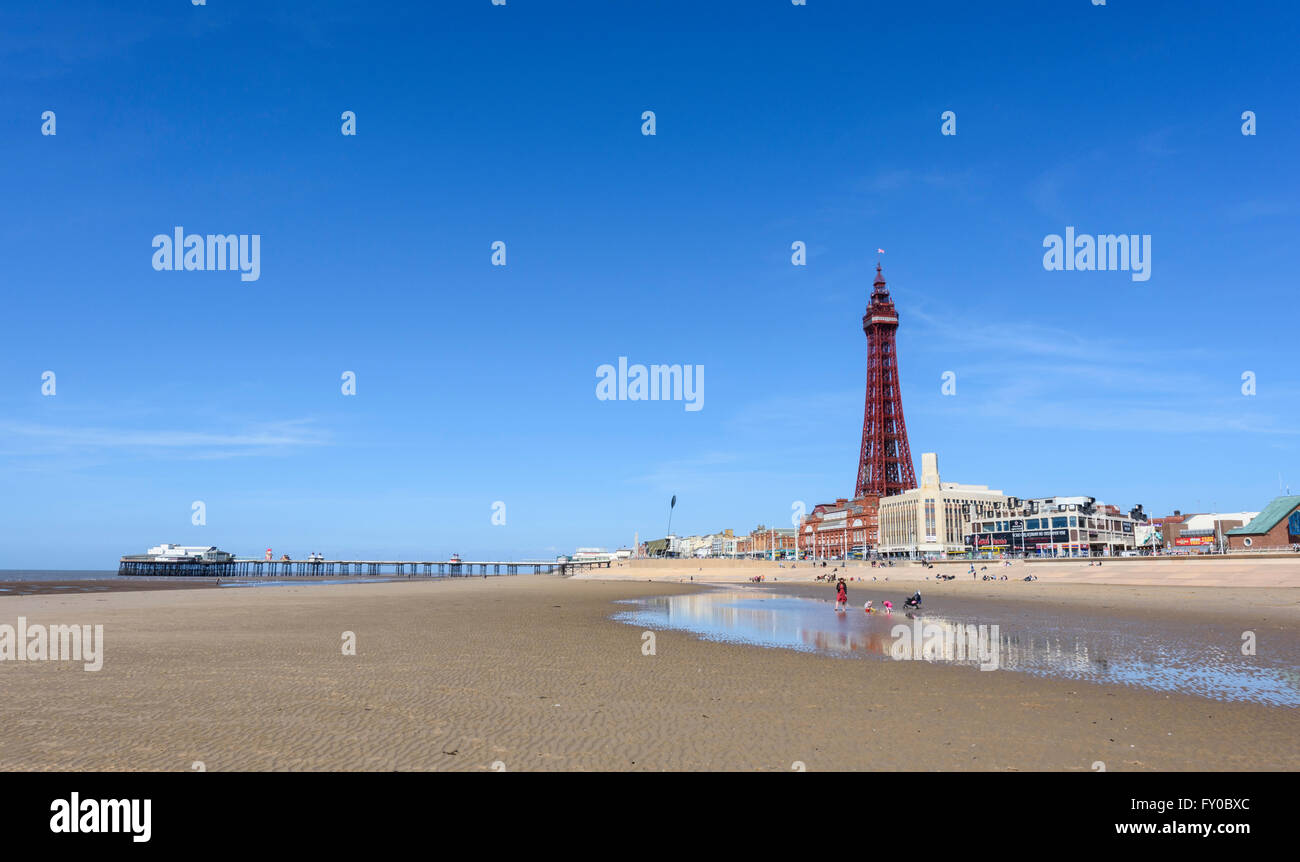 Sotto un luminoso cielo blu, la vista dalla spiaggia sabbiosa di North Pier e la mitica Torre di Blackpool in Blackpool Lancashire Foto Stock