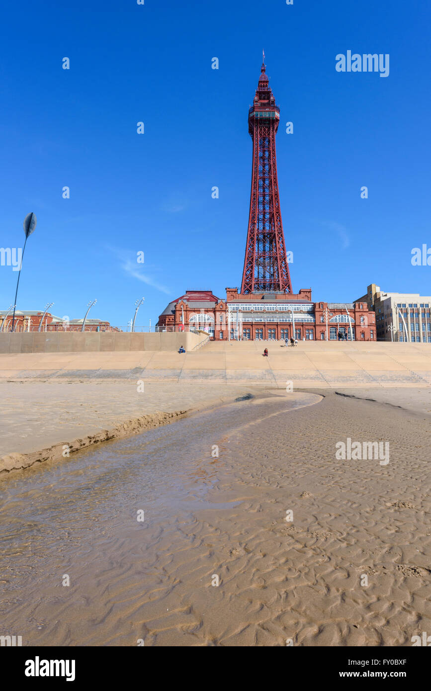 Sotto un luminoso cielo blu, la vista dalla spiaggia sabbiosa di la mitica Torre di Blackpool in Blackpool Lancashire Foto Stock