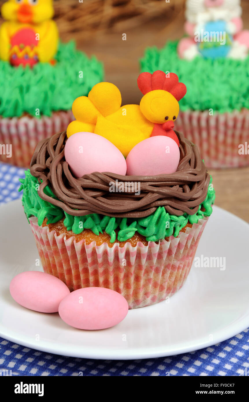 Muffin di Pasqua decorate gallina con uova seduto in un nido sull'erba Foto Stock