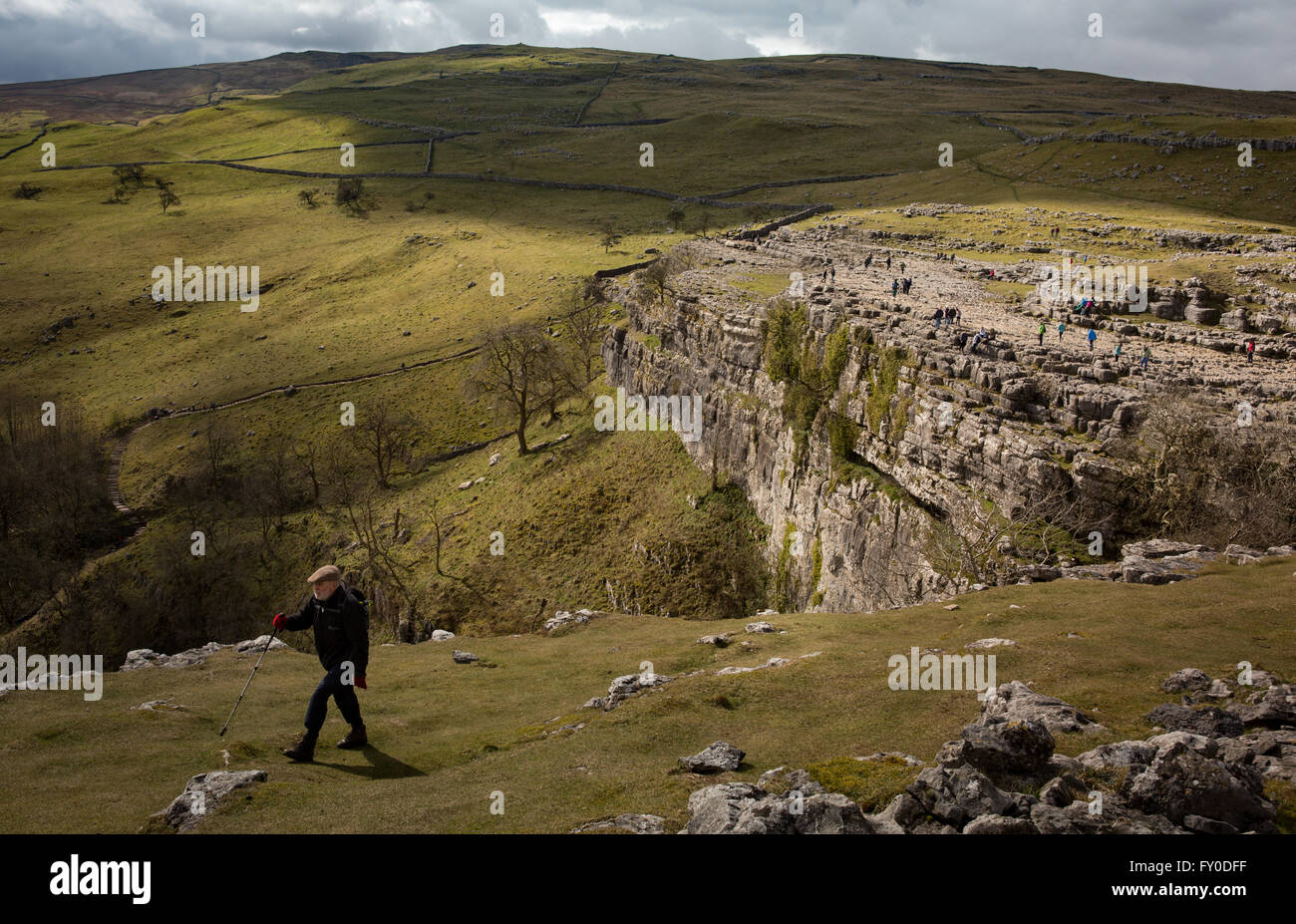 Un viandante segue un percorso in Malham Cove nel North Yorkshire, Inghilterra, Regno Unito. Foto Stock