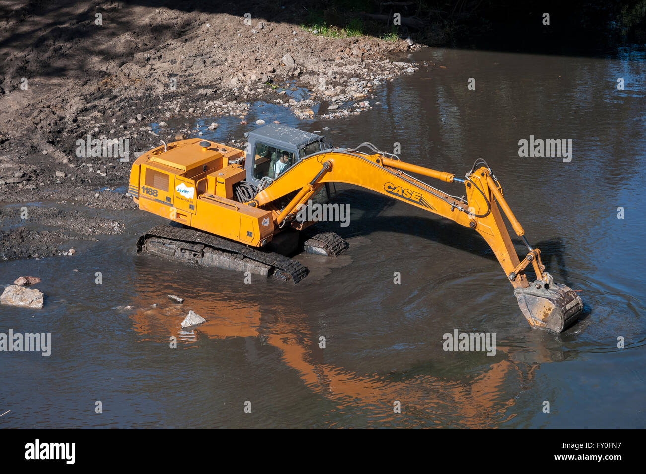 Il retroescavatore funziona nel fiume Bernesga, La Pola De Gordon, provincia di León, Spagna Foto Stock