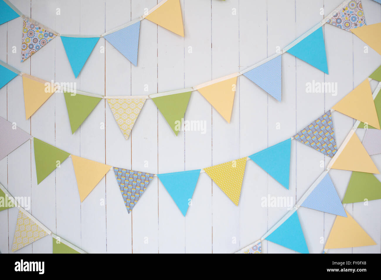 Compleanno di bandiere di decorazione su una pianura muro bianco shot con inclinazione e spostamento Foto Stock
