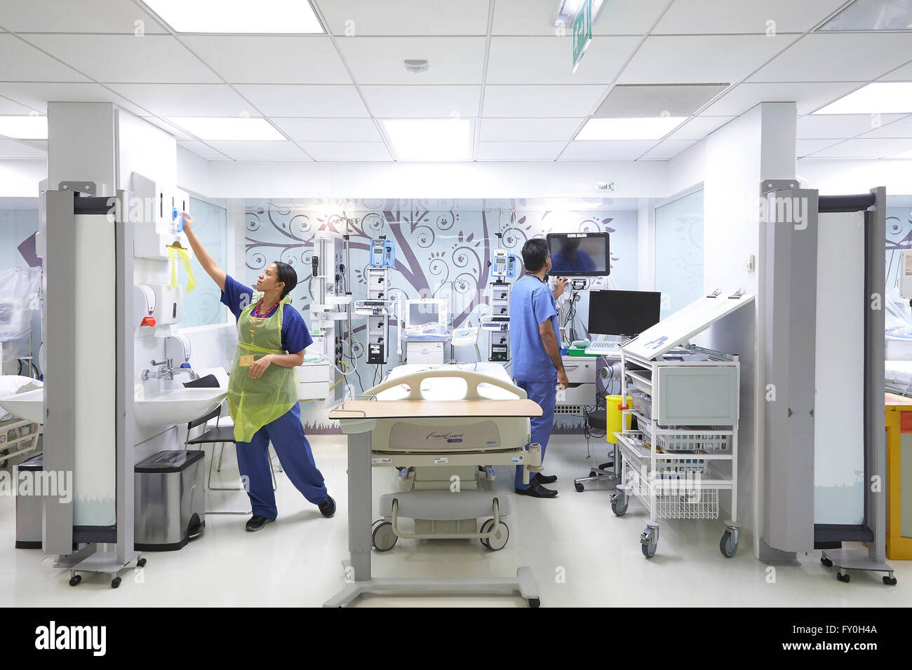 Medico e infermiere la preparazione di un letto di ospedale in un reparto privato nel Regno Unito. Foto Stock