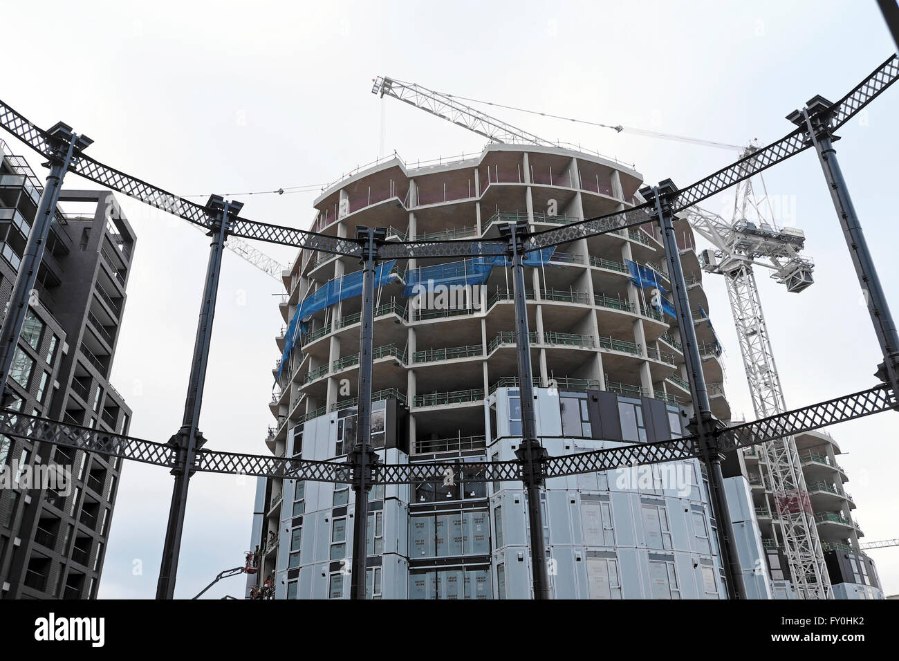 Il rivestimento al gasometro torre residenziale e gru su alloggiamento elite sito in costruzione Pancras bloccare lato canale in Kings Cross Londra UK KATHY DEWITT Foto Stock