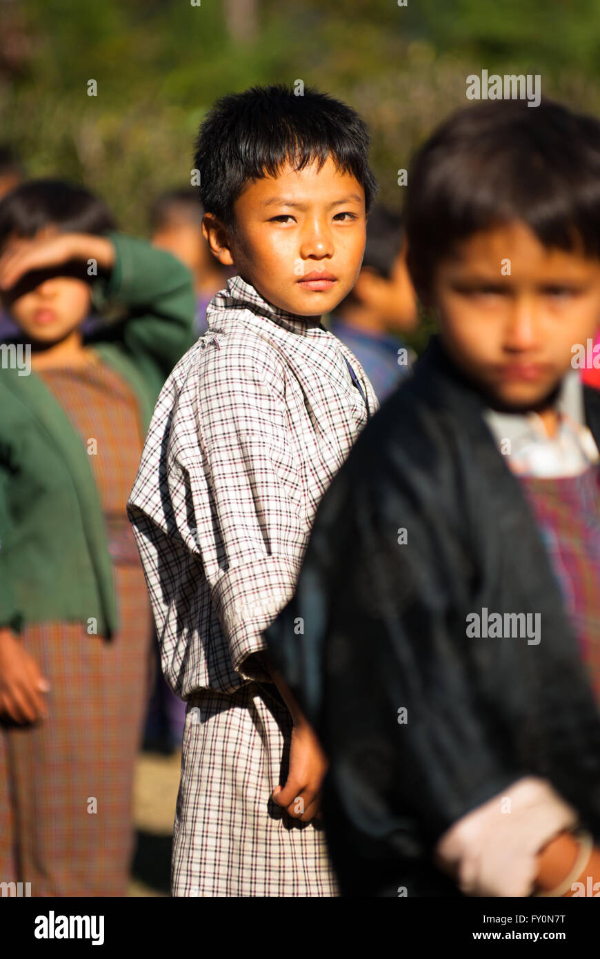 Gli studenti che indossano vestiti tradizionali al gruppo di mattina in una scuola elementare nel villaggio Nimshong nel sud del Bhutan Foto Stock