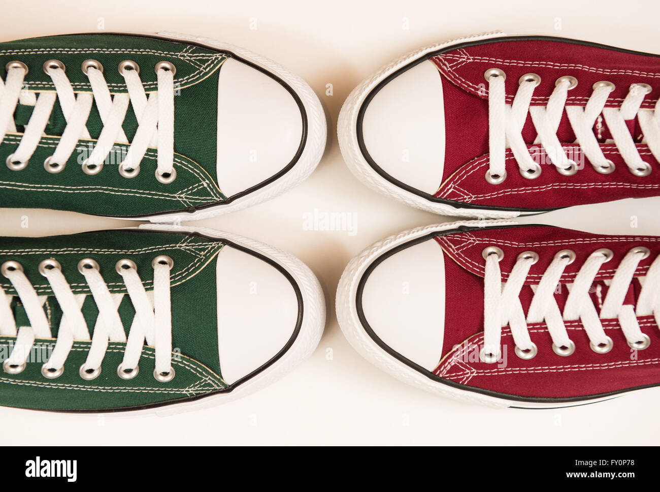 Verde e marrone rossiccio sneakers su uno sfondo bianco che rappresentano i colori di Hibernian e il cuore di Midlothian football club Foto Stock