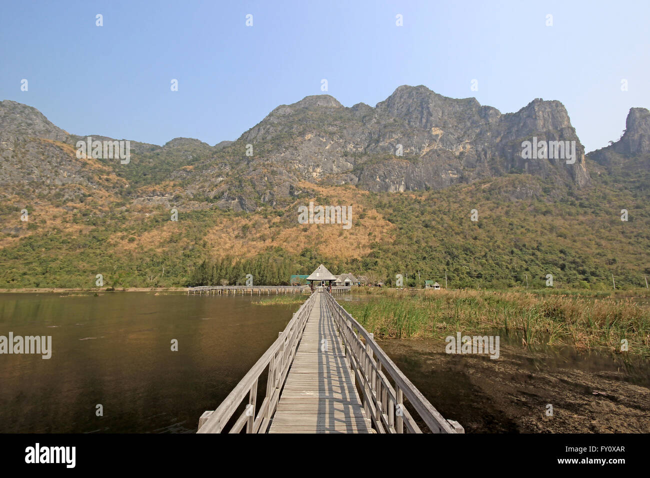 Lungo pontile in legno sulla natura lago di montagna e bello sfondo cielo Foto Stock